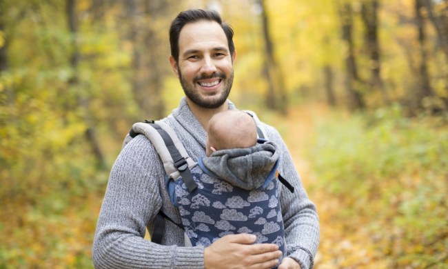 A dad wearing his baby in a carrier.