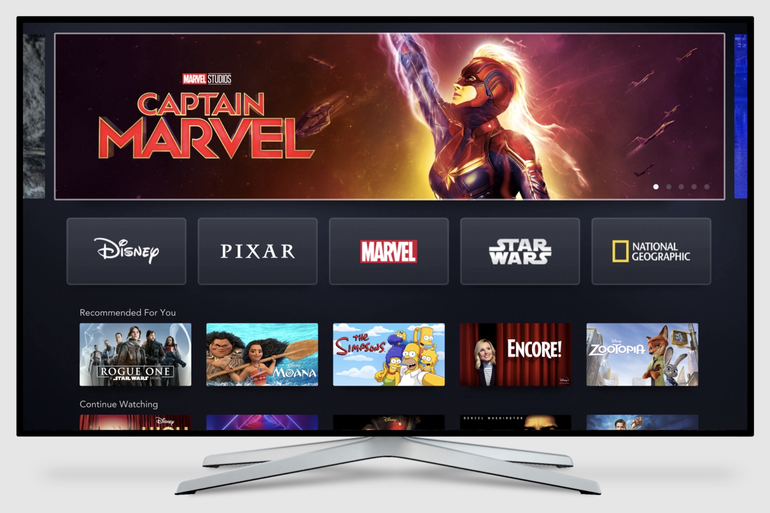 a large TV screen shows the homepage to Disney+