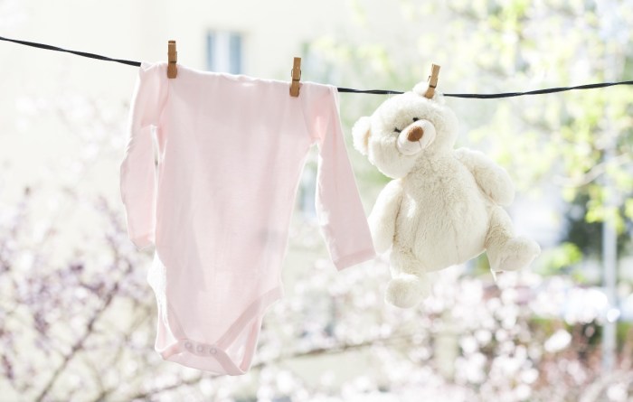 Baby laundry and plush bear drying on a line