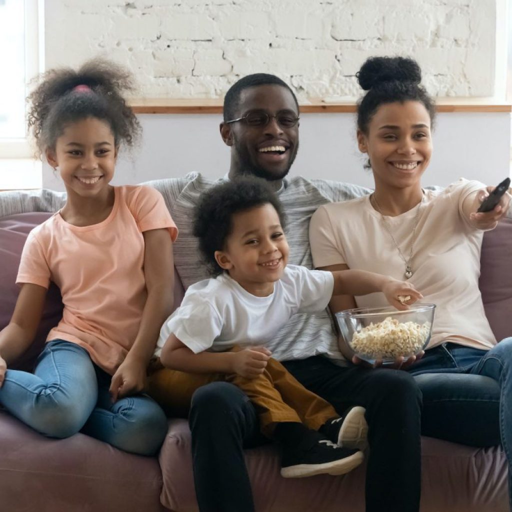 A family watches TV on a couch
