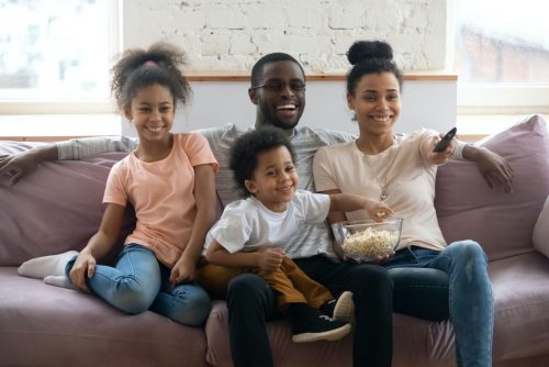A family watches TV on a couch