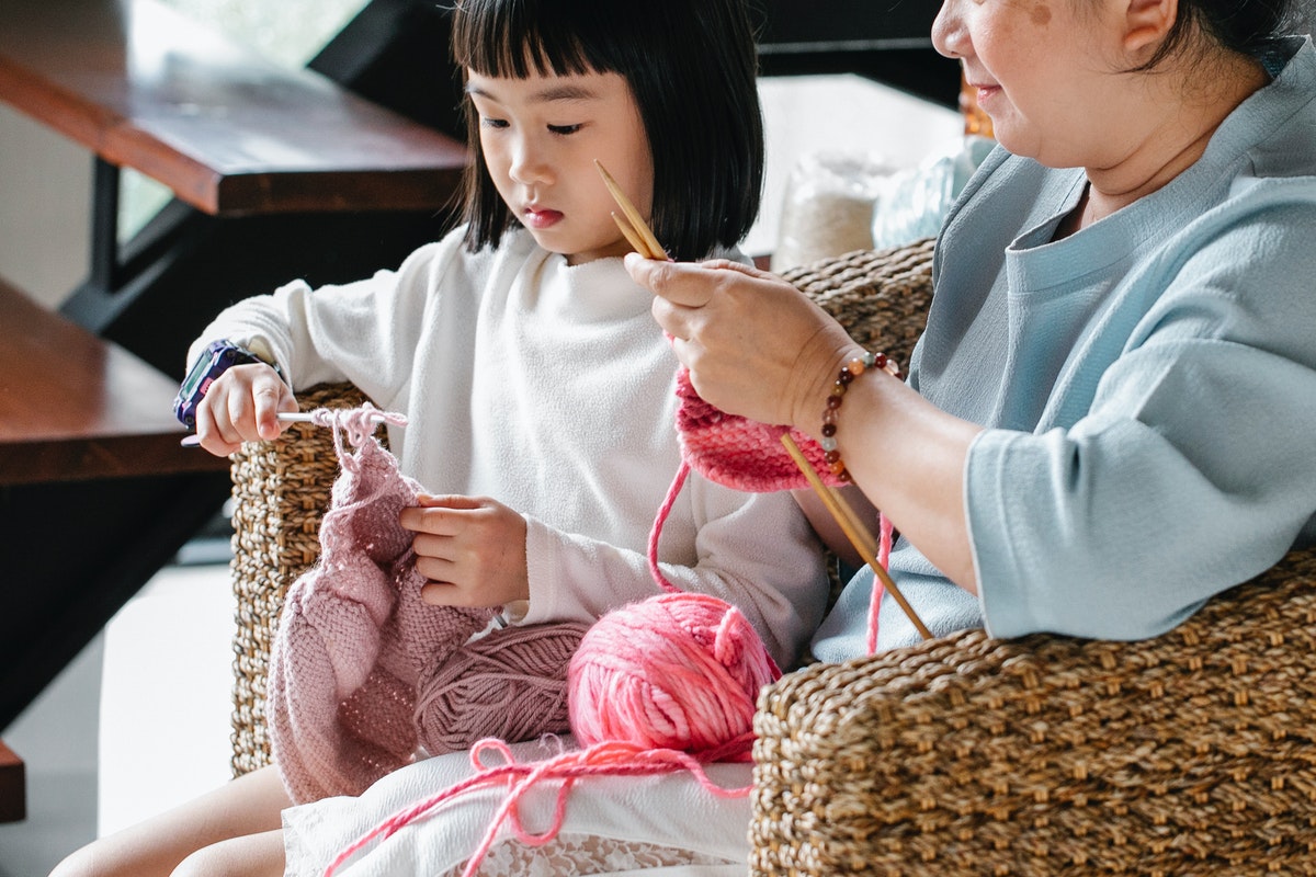 Girl knitting with grandmother