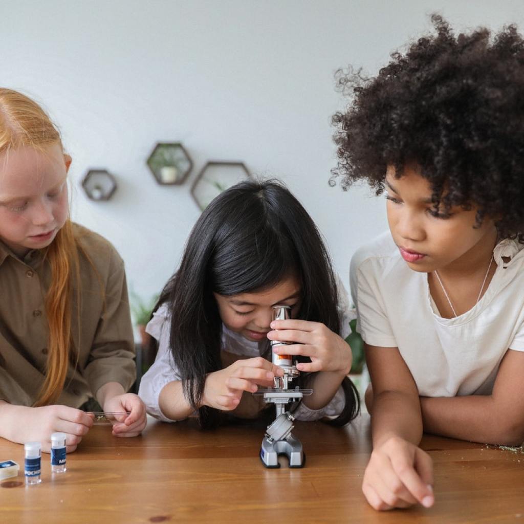Three young girls using a microscope