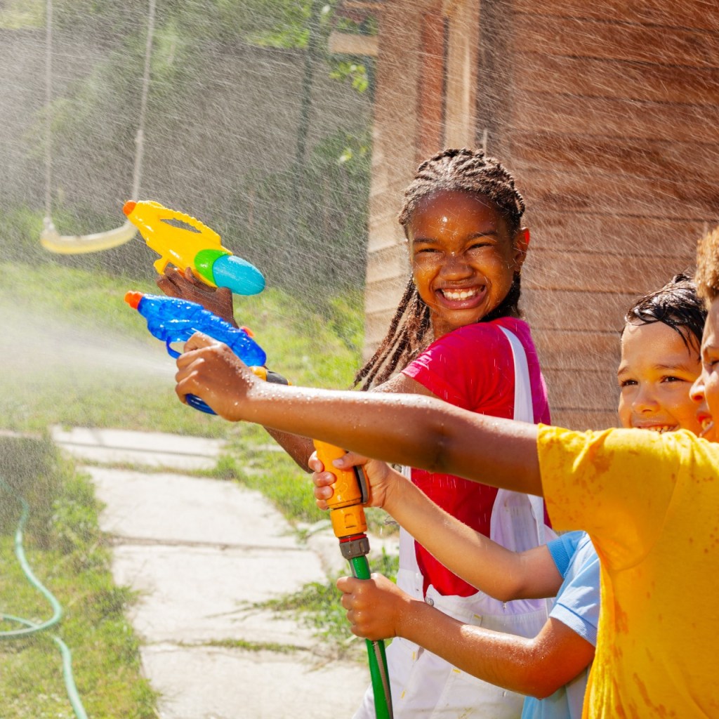 Kids playing with squirt guns in the yard