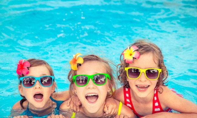 Kids having fun in a pool and wearing sunglasses.
