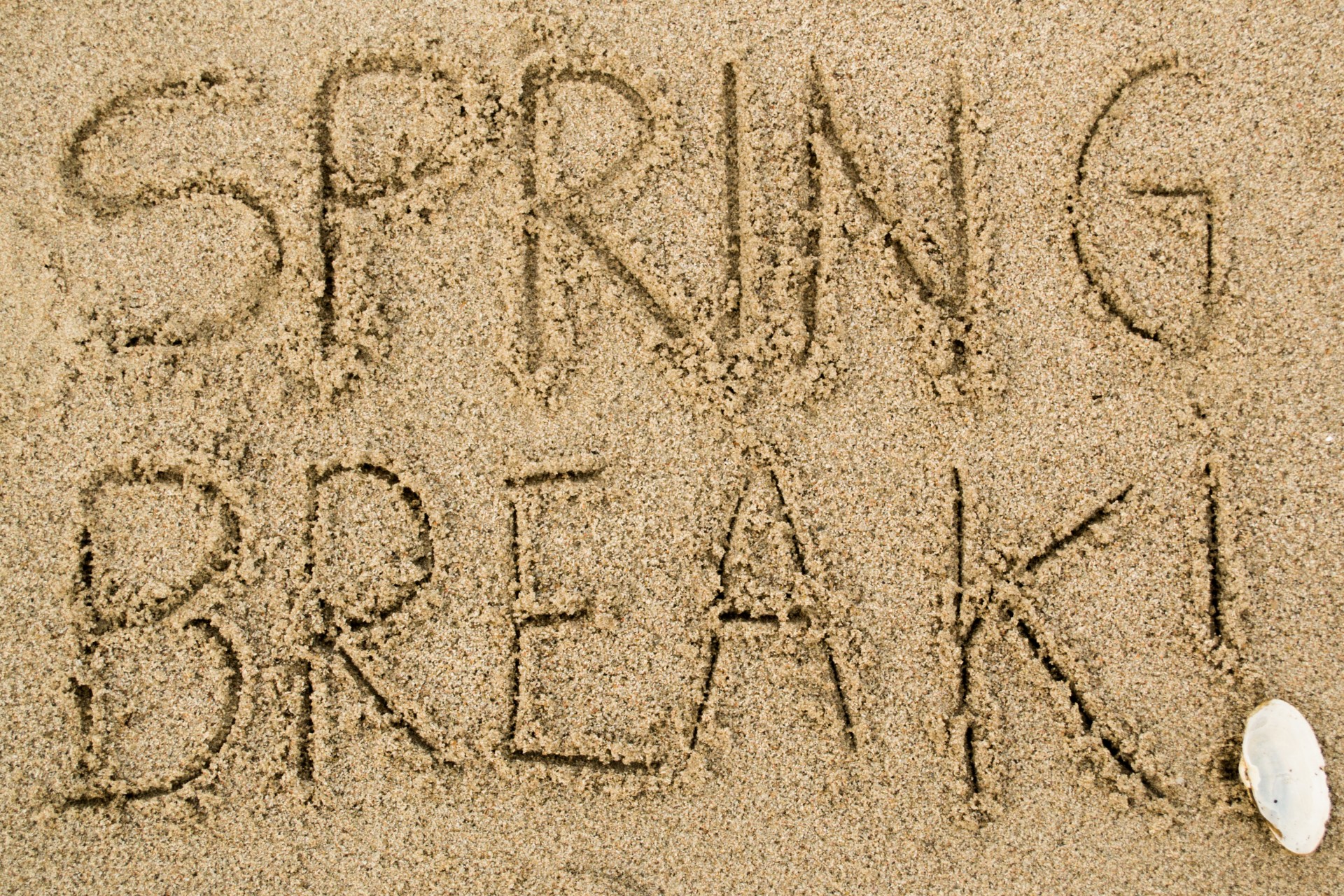 The words "spring break" written in sand