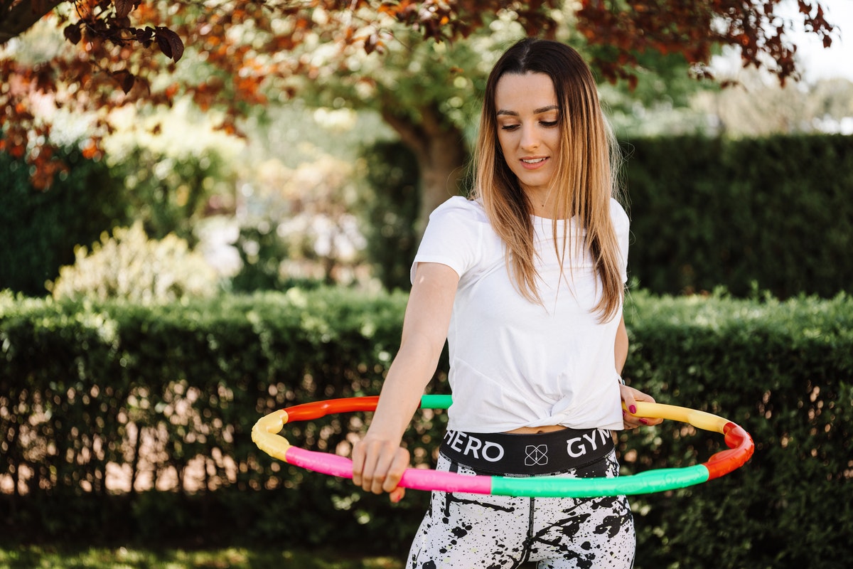A teenager playing with a hula hoop