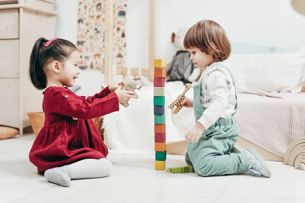 Two toddlers playing with blocks