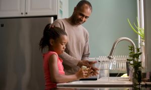 Father and daughter washing their hands