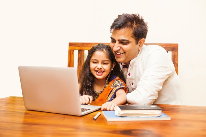 Dad using a laptop with his daughter