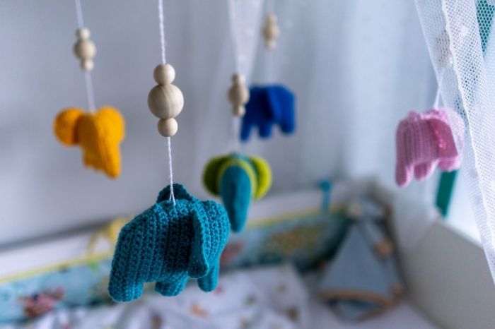 A crib with a toy-elephant mobile