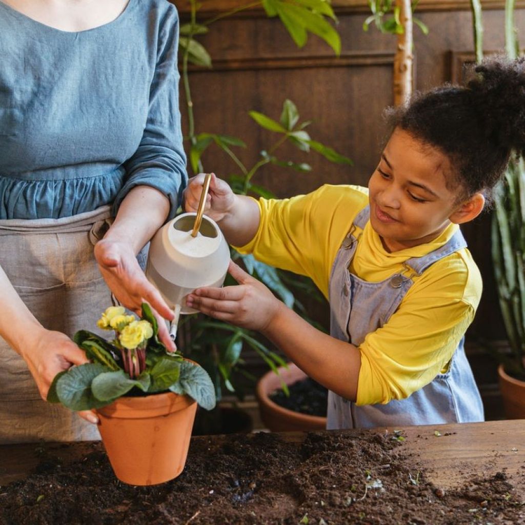 Mom and daughter watering plants
