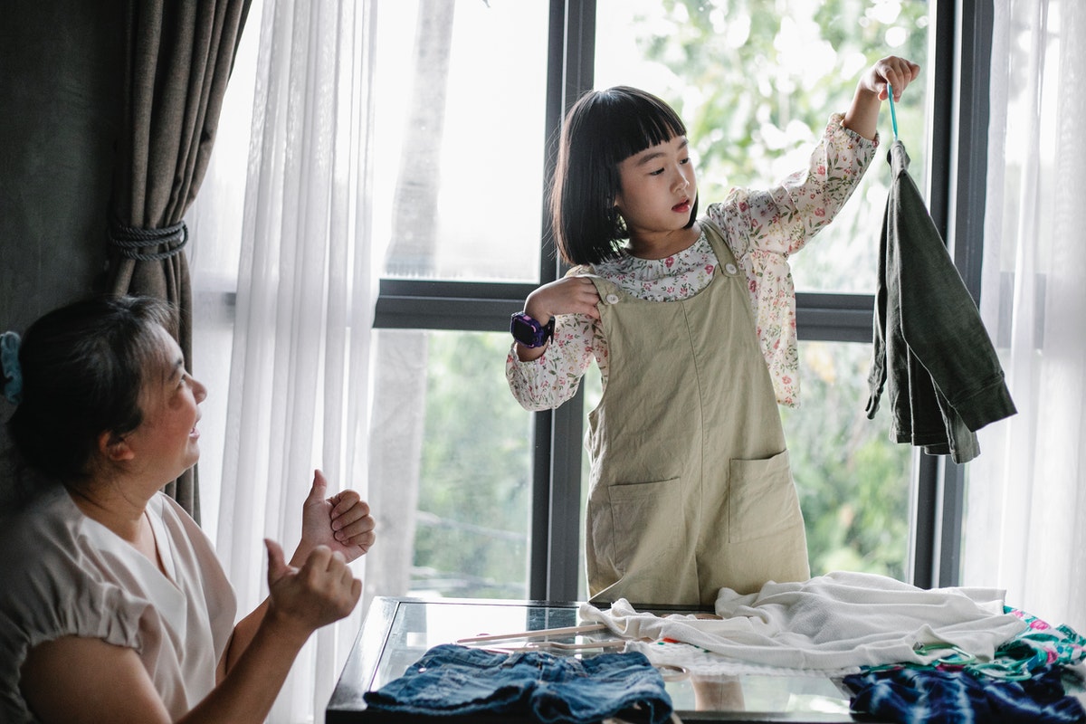Little girl hanging up clothes for her grandmother