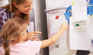 Mother and daughter looking at a behavior chart
