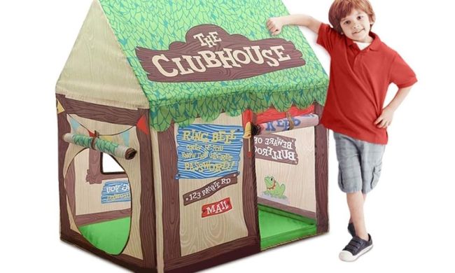 Child standing near a play tent