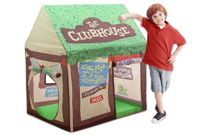 Child standing near a play tent