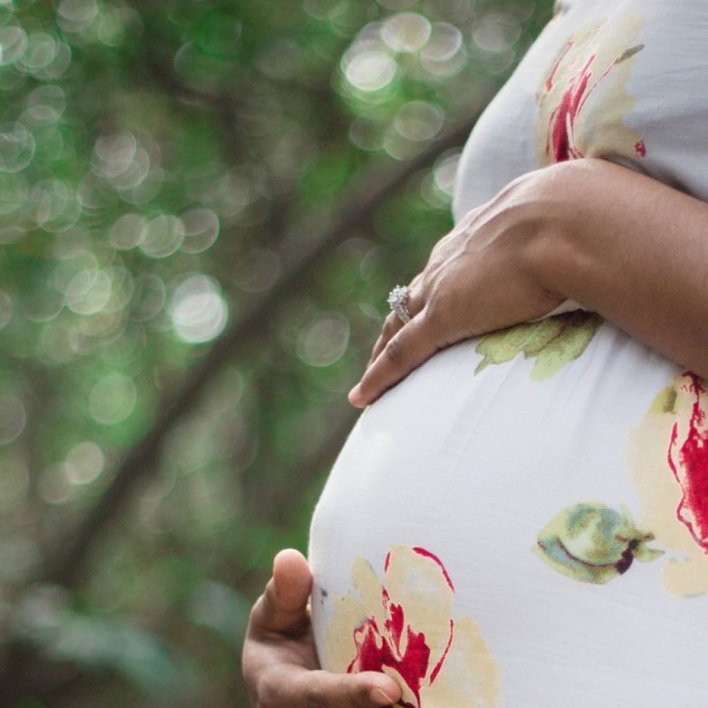 Pregnant married woman standing in a floral gown