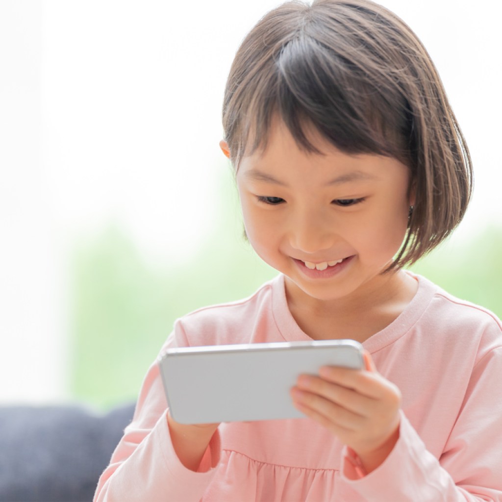 Little girl having fun playing on a smartphone