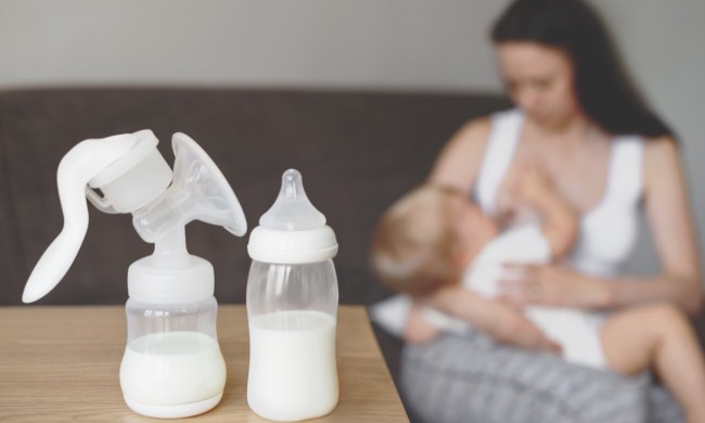Mom breastfeeding and manual breast pump on the table