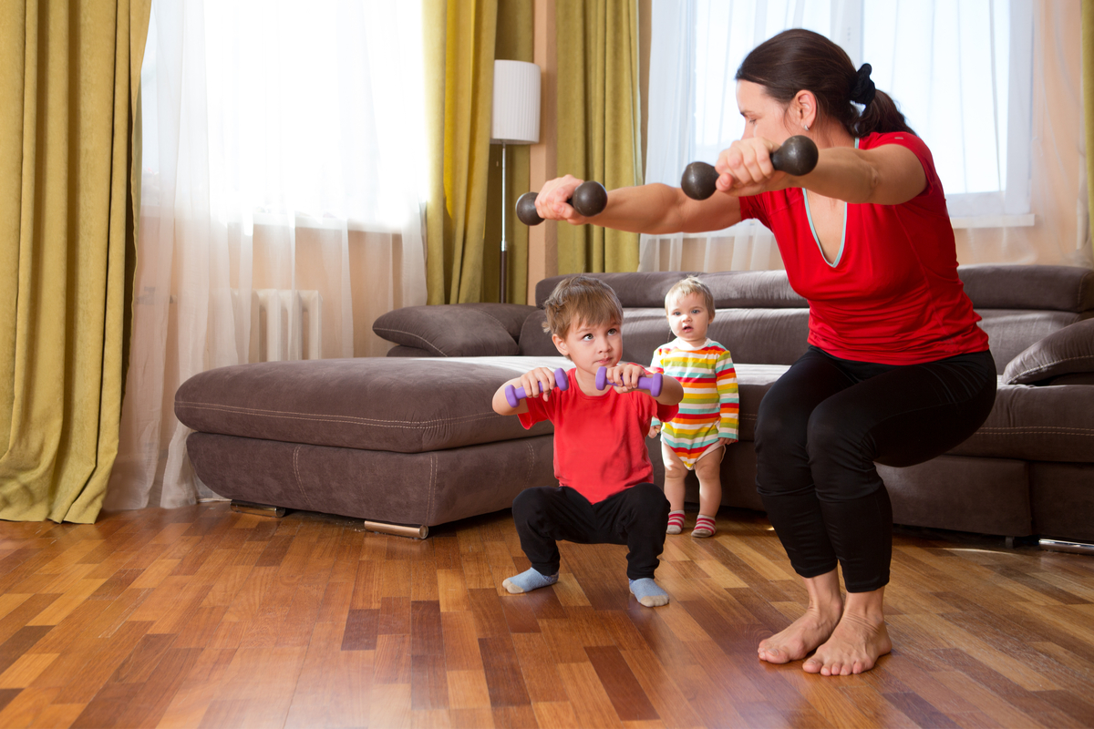 Mom working out with her todlers joining in