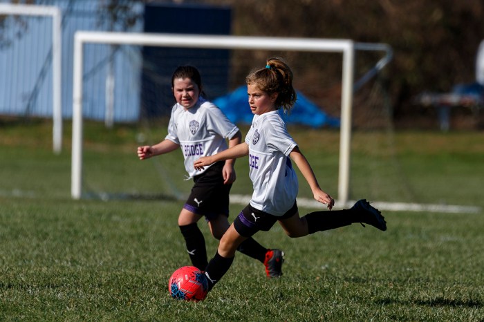 Two girls having fun playing travel soccer