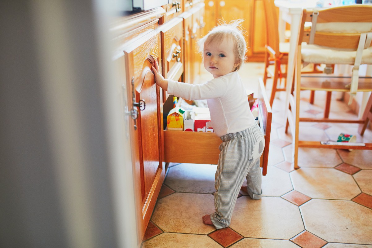 baby going through drawers in kitchen