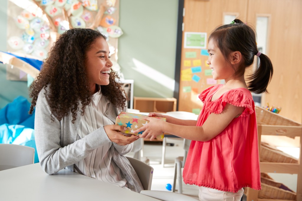 Preschooler giving her teacher a present