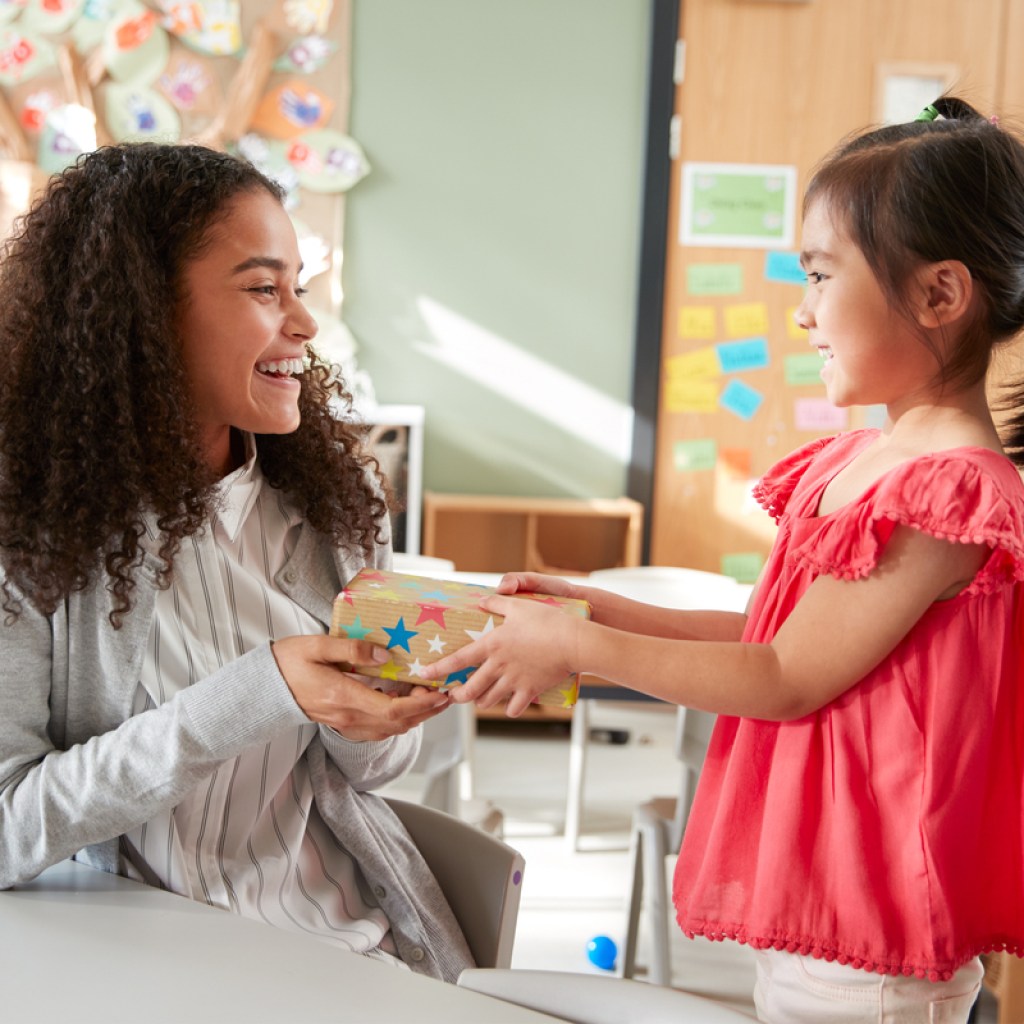 Preschooler giving her teacher a present