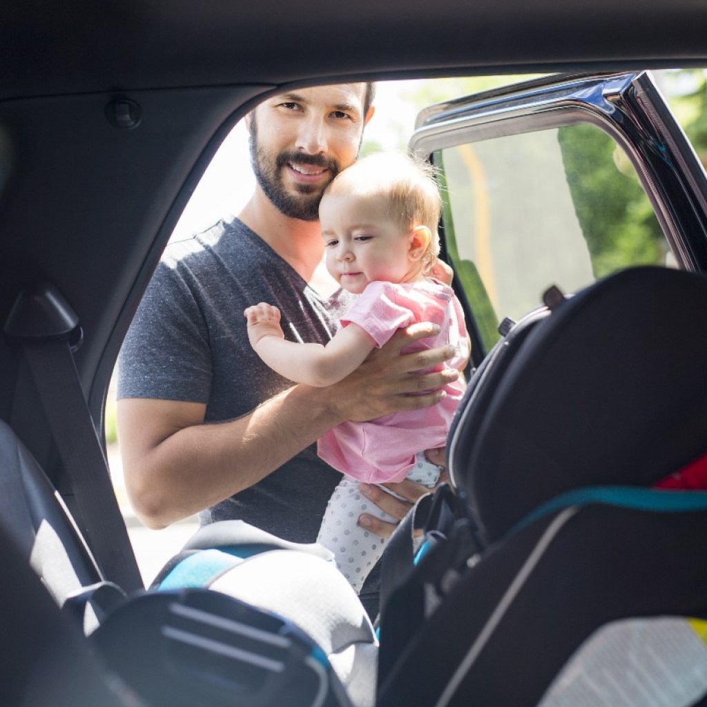 dad putting baby in rear-facing car seat