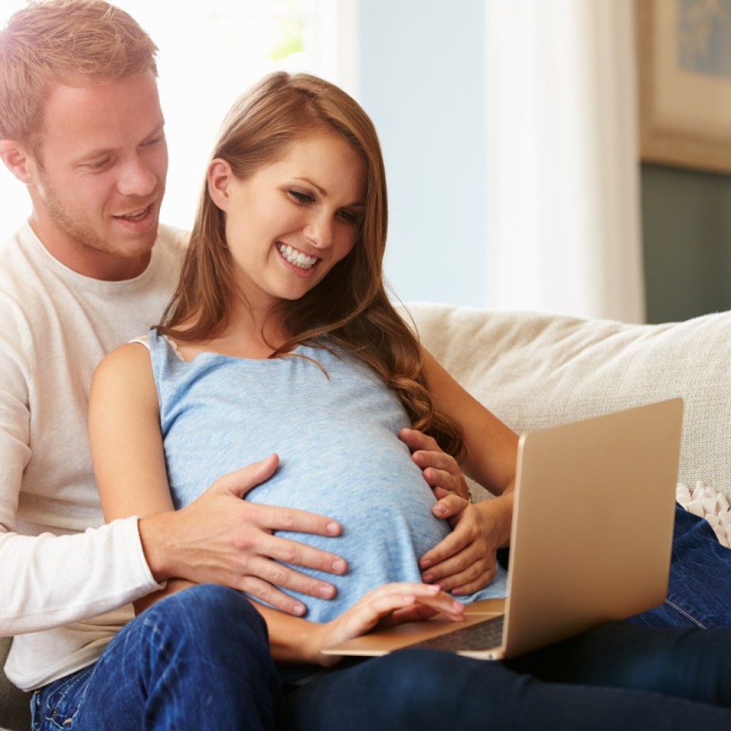 Expecting mom and dad on computer.