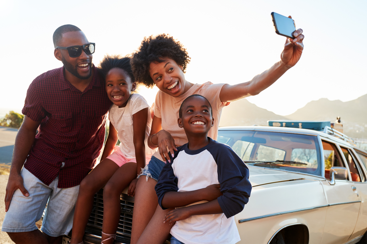 Family posing for a selfie on a road trip