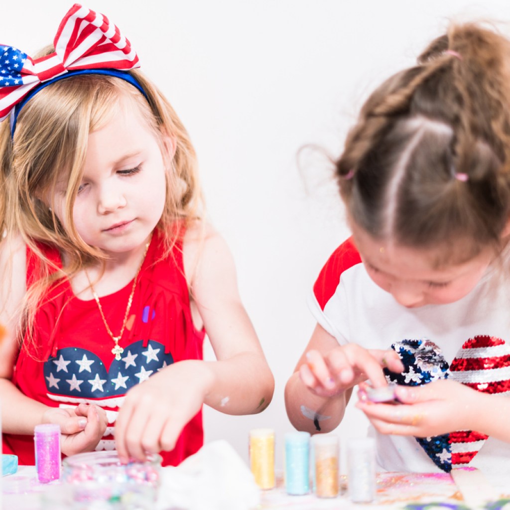 Two little girls making July Fourth crafts