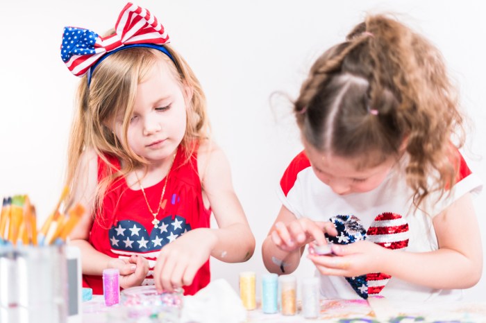 Two little girls making July Fourth crafts