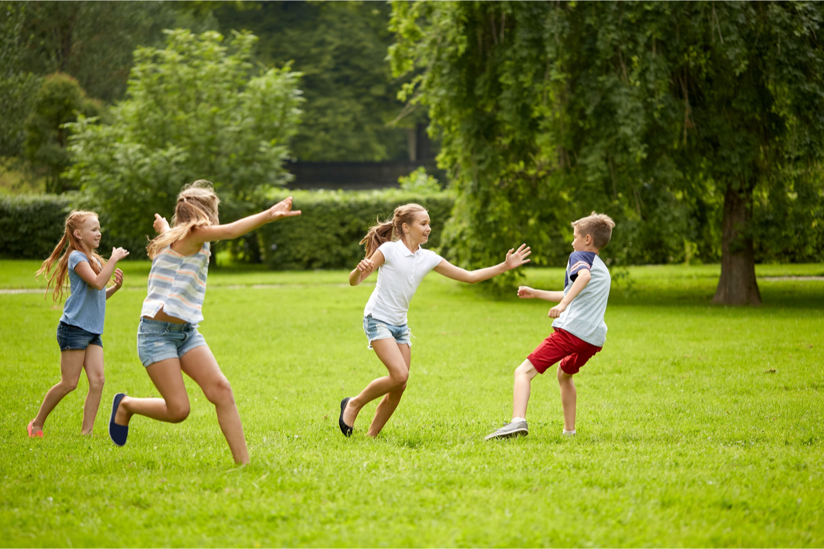 Kids having fun playing tag in the park