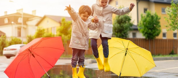 Kids wearing rain boots near puddles