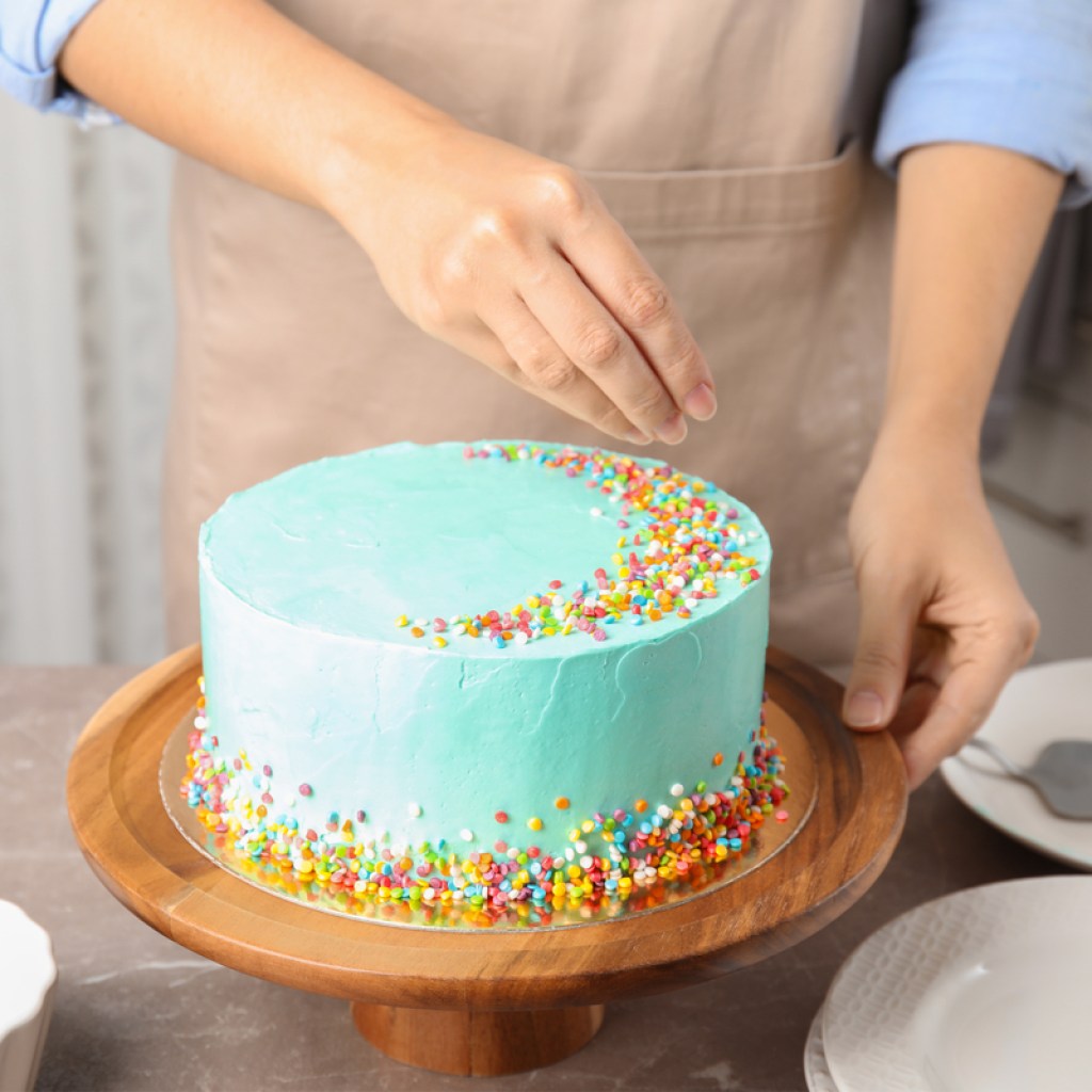 mom decorating cake with sprinkles