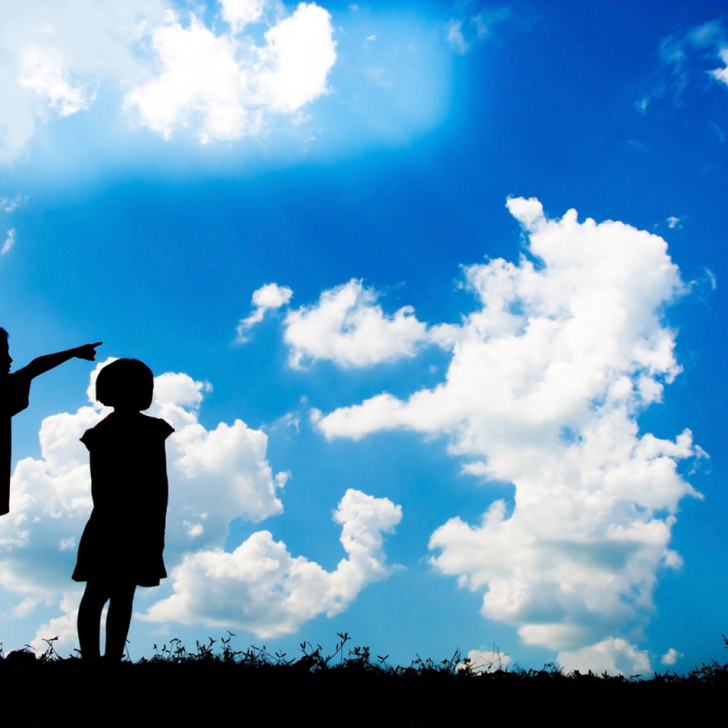 two kids looking up at cloud shapes