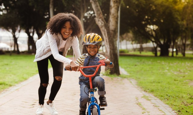 Woman with young son on a bike in a park
