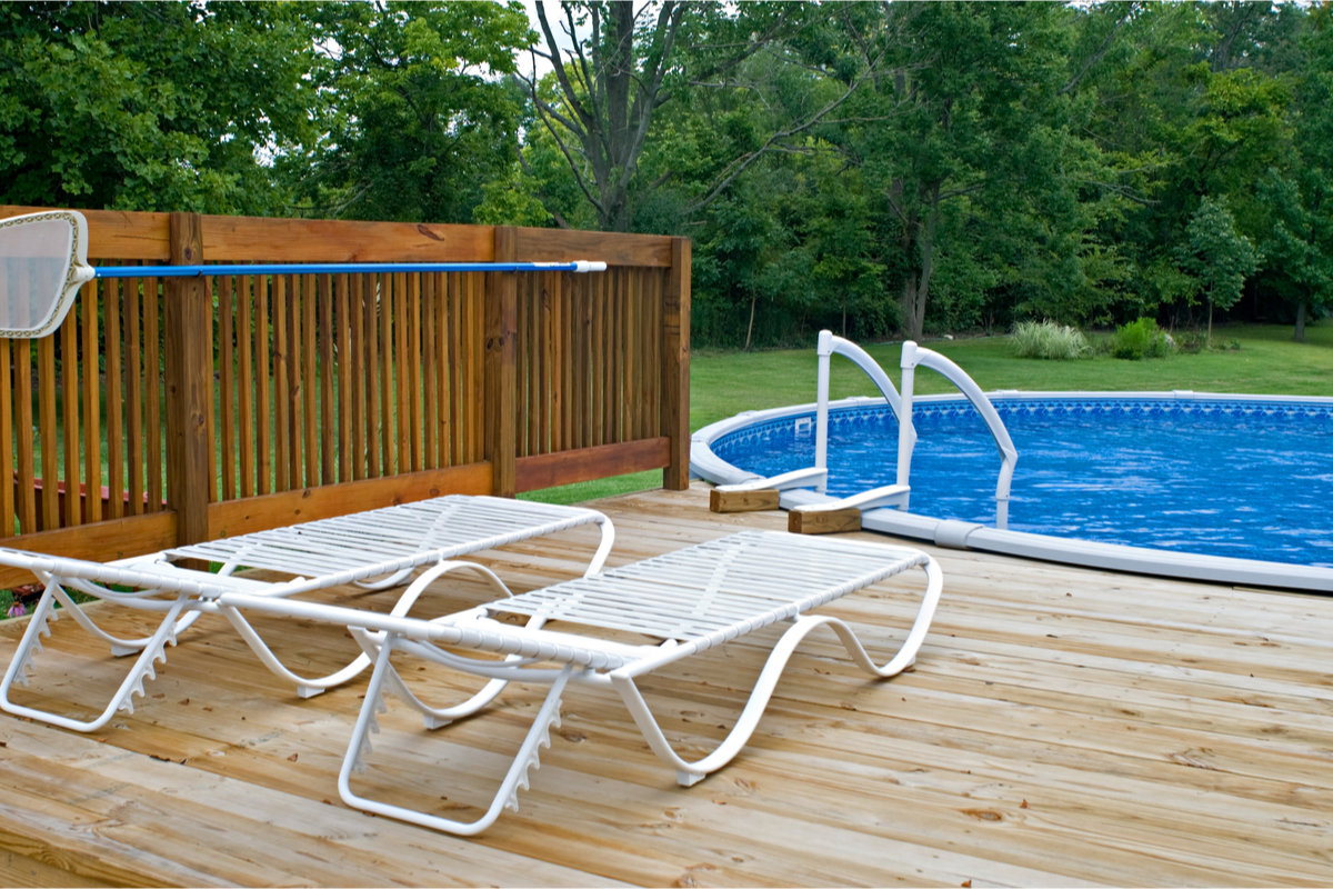 backyard above ground pool with a deck