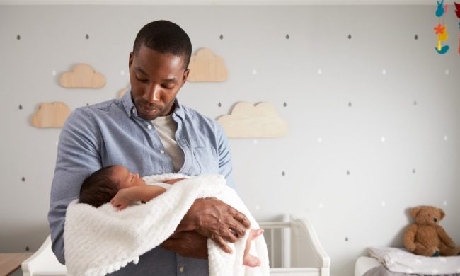 Dad holding baby in the nursery.