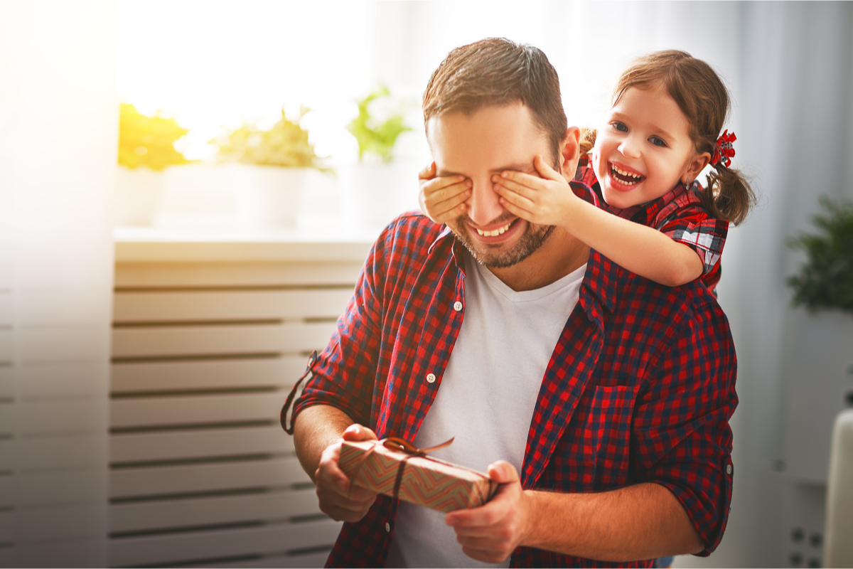 Little girl with dad holding a wrapped gift