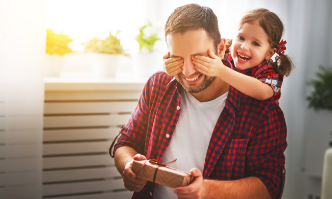Little girl with dad holding a wrapped gift