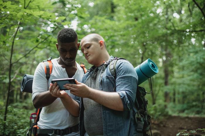 Two men looking at a smartphone in the woods