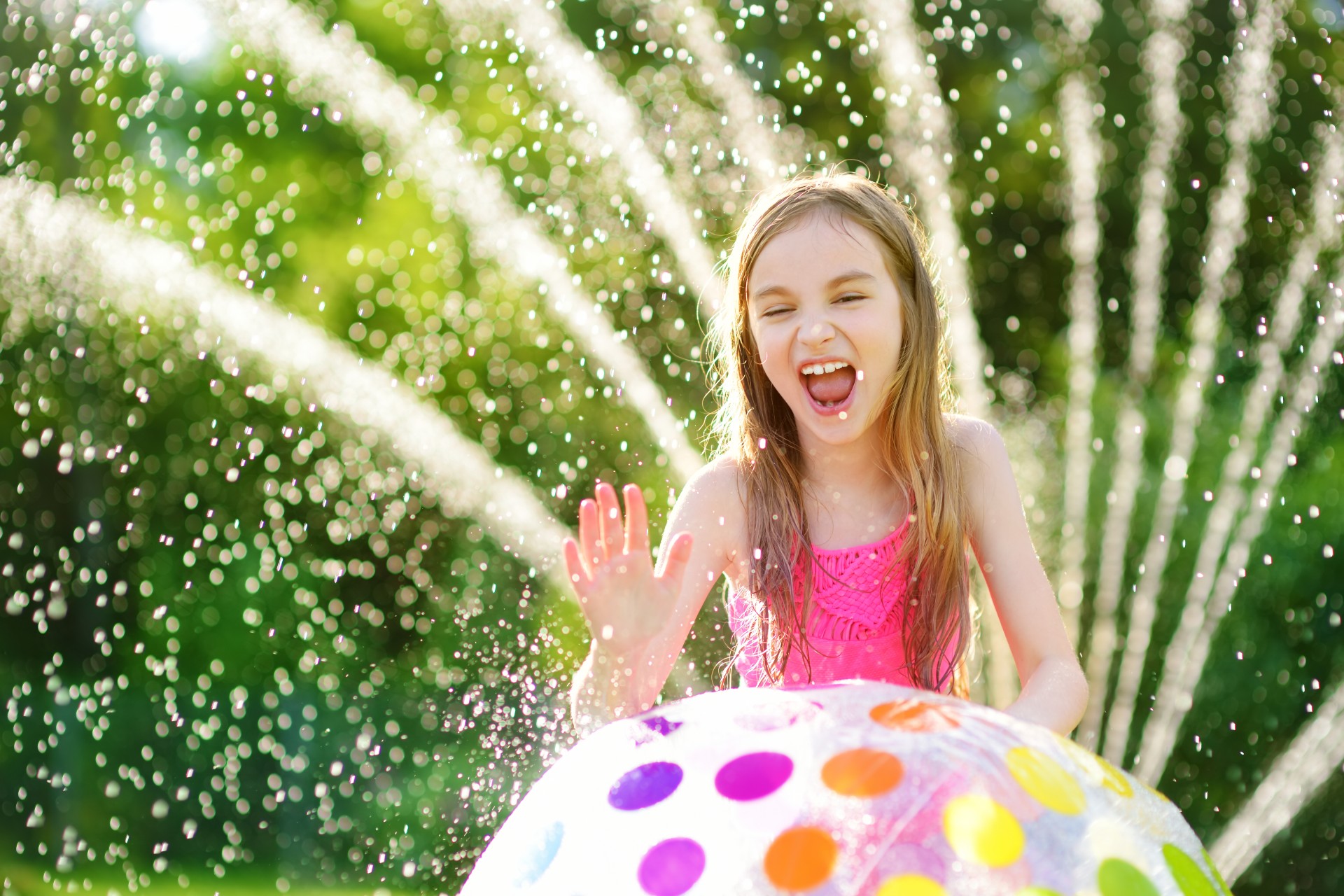Girl laying with a sprinkler