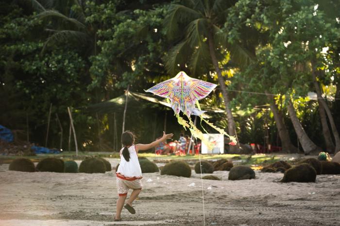 Girl playing with kite on a beach