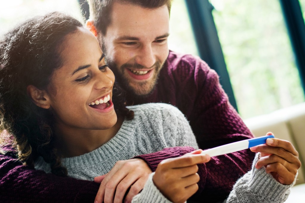 Couple smiling at pregnancy test