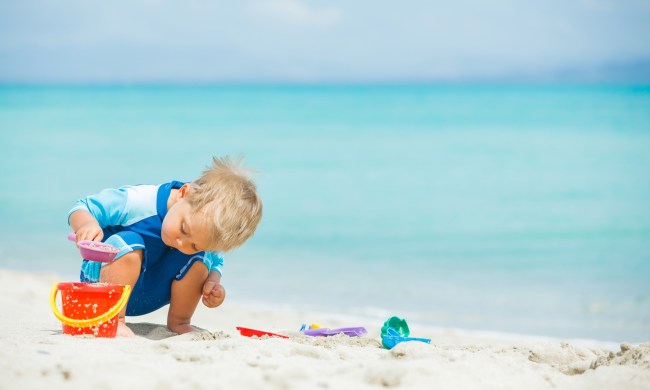 Little boy making a sandcastle at a beach