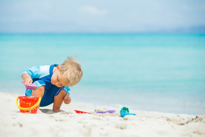 Little boy making a sandcastle at a beach
