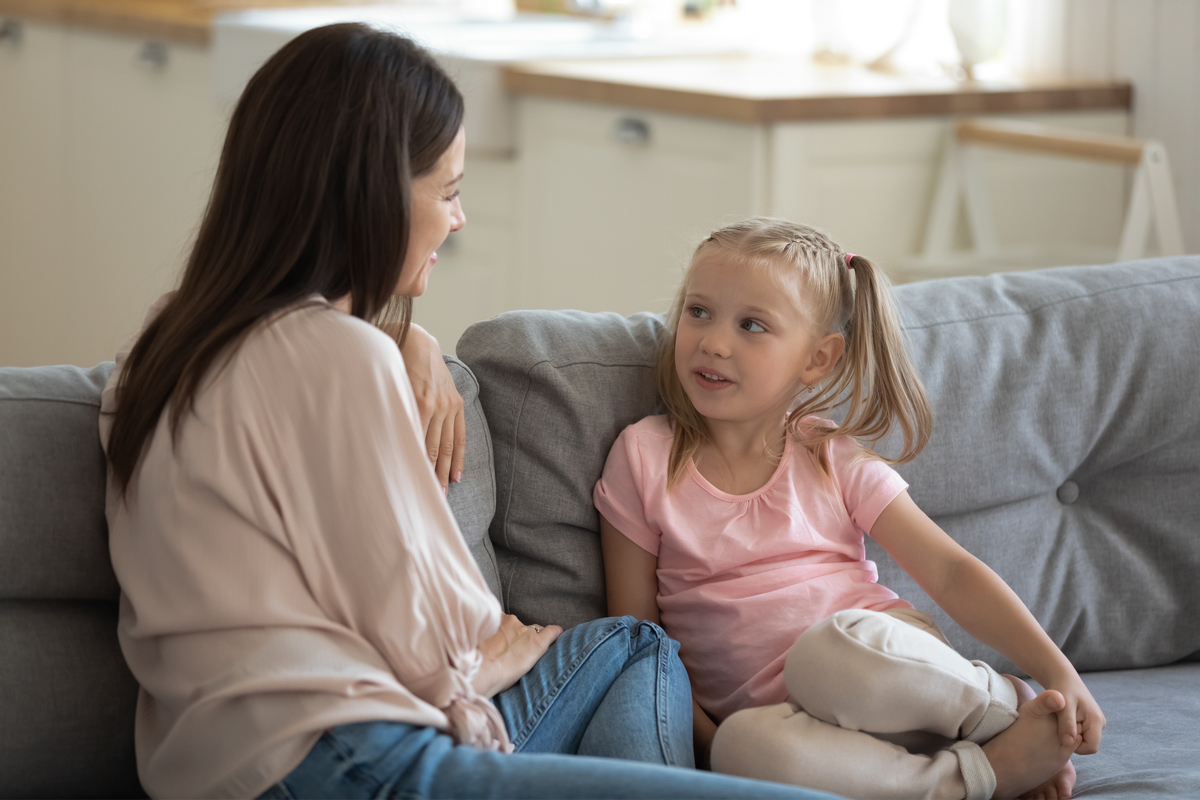 Mom and preschooler talking on a couch