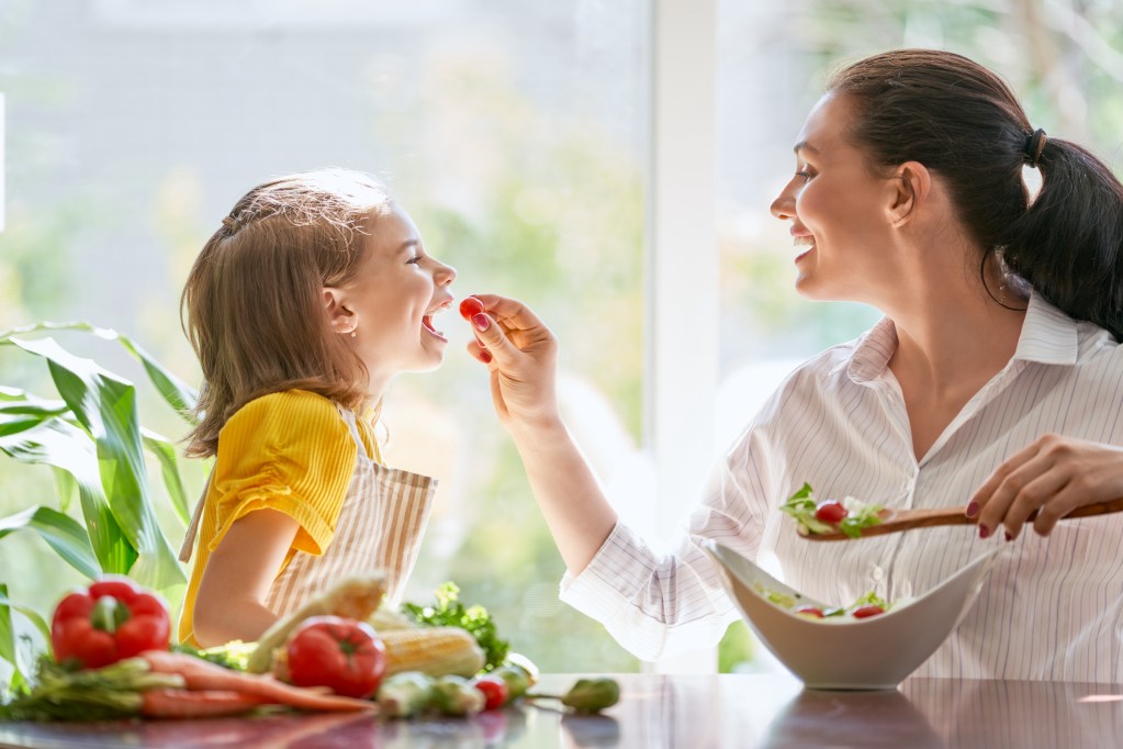 Mother and daughter eating vegetables